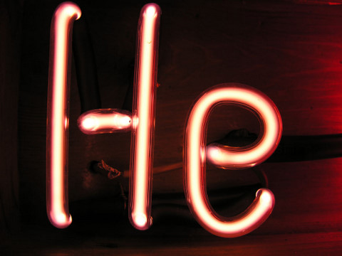Lysrør formet som bokstavene H og e fylt med helium som gir en hvitoransje farge 
